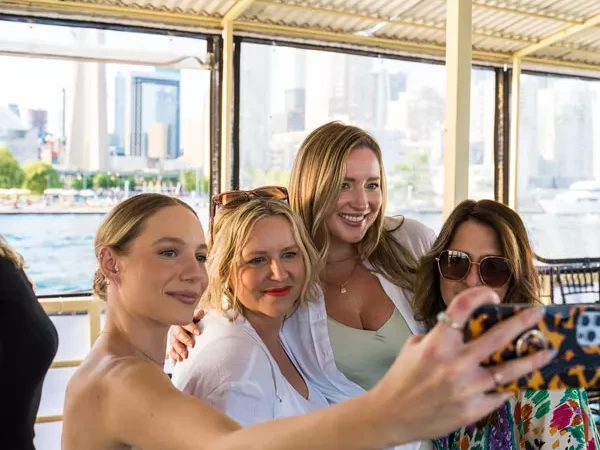 girls posing on a boat taking a group selfie